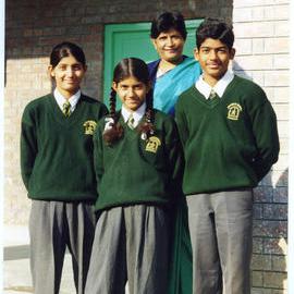 Three scholarship students for St.Thomas School, stand with Mrs. Singh