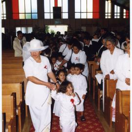 Children and women dressed in white walk down the aisle at Glen Eden Pacific Islanders Church during a White Sunday service, 2002 