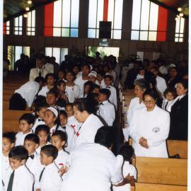 Children, men and women walk down the aisle at Glen Eden Pacific Islanders Church during White Service, 2002