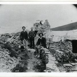 Reverend George McNeur and two Chinese men beside their rock dwelling, Potter's Gully