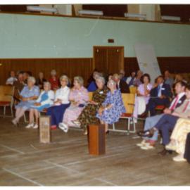 Seated parishioners fill a sports gymnasium, Cromwell Church