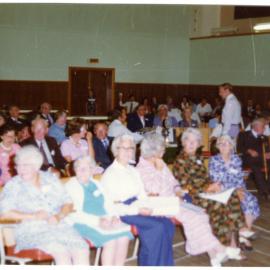 Seated parishioners fill a sports gymnasium, Cromwell Church