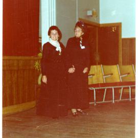 Two women stand in a sports gymnasium wearing period clothing, Cromwell Church