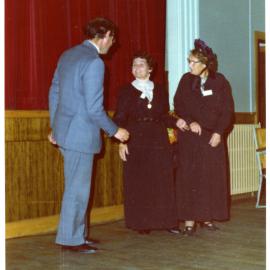 Two women in period clothing address a man in a grey suit, Cromwell Church