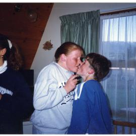 An unidentified girl and boy exchange a playing card, during a game. 