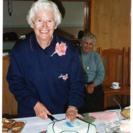 Peggy Weir cutting cake for the fourth anniversary for St. Columba's walking group, 1995