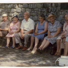 Unidentified women and men of St. Columba, are seated at the Memorial for Horses, Ford Milton Home, 1986