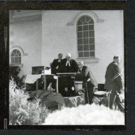 Unidentified man standing at a podium, talking to another unidentified man, John Knox, Rangiora, 1972