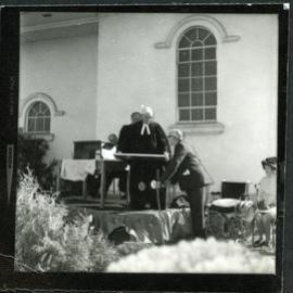 Unidentified man standing at a podium, talking to another unidentified man, John Knox, Rangiora, 1972