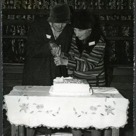 Two unidentified women cut the centenary cake, John Knox Church, Rangiora, 1972