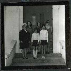 Six unidentified young girls stand at the steps of John Knox Church, 1972