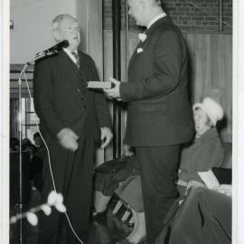 Bill Goss and unidentified man during a ceremony, with Elinor Wilson in the background