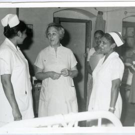 Beryl Howie is talking to two unidentified Indian nurses, another unidentified Indian nurse is in the background with a patient