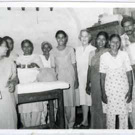 Beryl Howie stands with unidentified women (presumably patients), with one woman holding metal medical equipment, Ludhiana