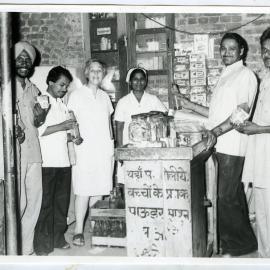 Beryl Howie and five unidentified Indian men and one woman, who are enjoying a beverage and a snack, Ludhiana