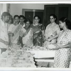 Unidentified women dressed in saris serve a meal