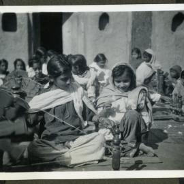 Two unidentified young women spinning thread during class, Jagadhri Girls' School, 1941