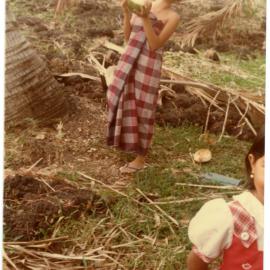 Evelyn Kapa Carrying a Young Coconut