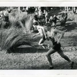 "Lyn Jones (8th) leading the field out of the first bog, in the junior race," 1964 Dorne Cup at Trentham, Presbyterian Harrier Club - Wellington