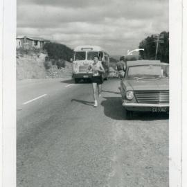 "Malcolm Shaw pursued by the Club bus at the top of Kaitoke Hill," Masterton Relay, 1964, Presbyterian Harrier Club - Wellington