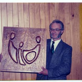 Rev. Bill Wallace holding a wooden artwork