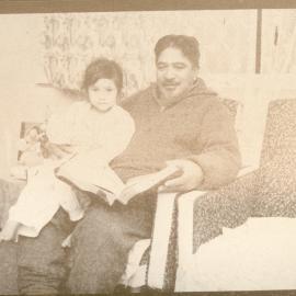 Mr E. Waiariki Reading With His Child (Pat or Honey) 