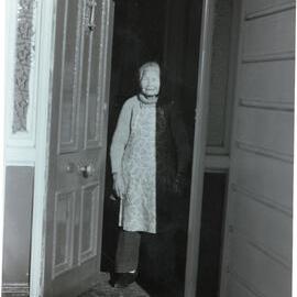 Mrs Gin at doorway of her home