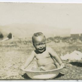 Māori child in a bathing bowl