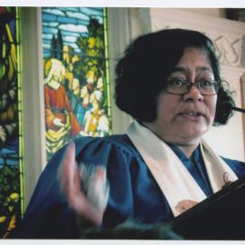 Rev. Alofa Lale in front of a stained glass window