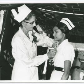 Sister Jean Hanning pins a nursing badge