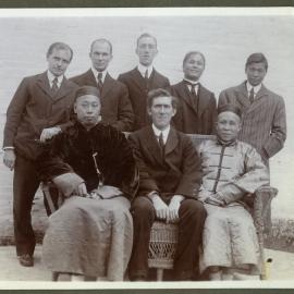 Doctor John Kirk and Doctor Edward Kirk sit among unidentified Chinese and European mean, 1910