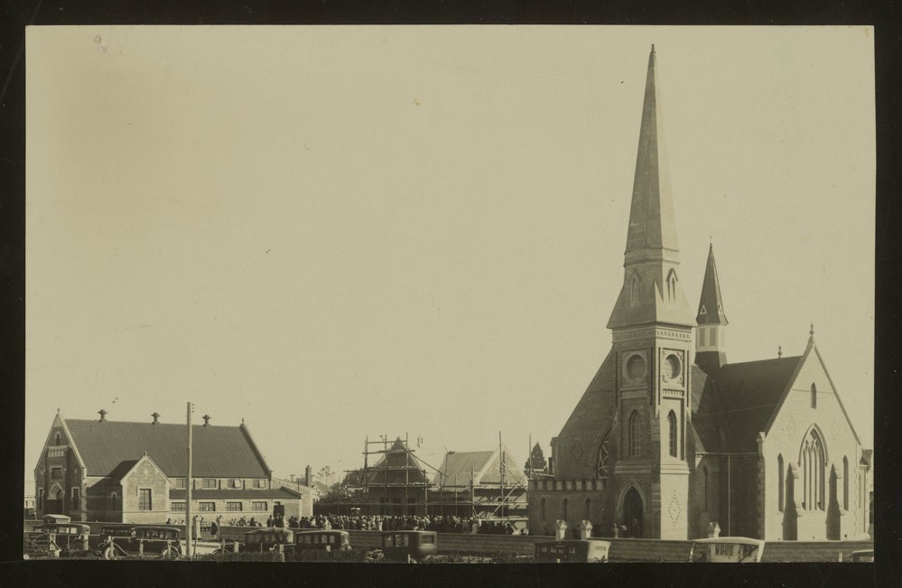 Temuka Church, Hall and adjoining building - under repair or construction with a large number of people attending Jubilee celebrations, and cars parked on the street.
P-A3.50-133