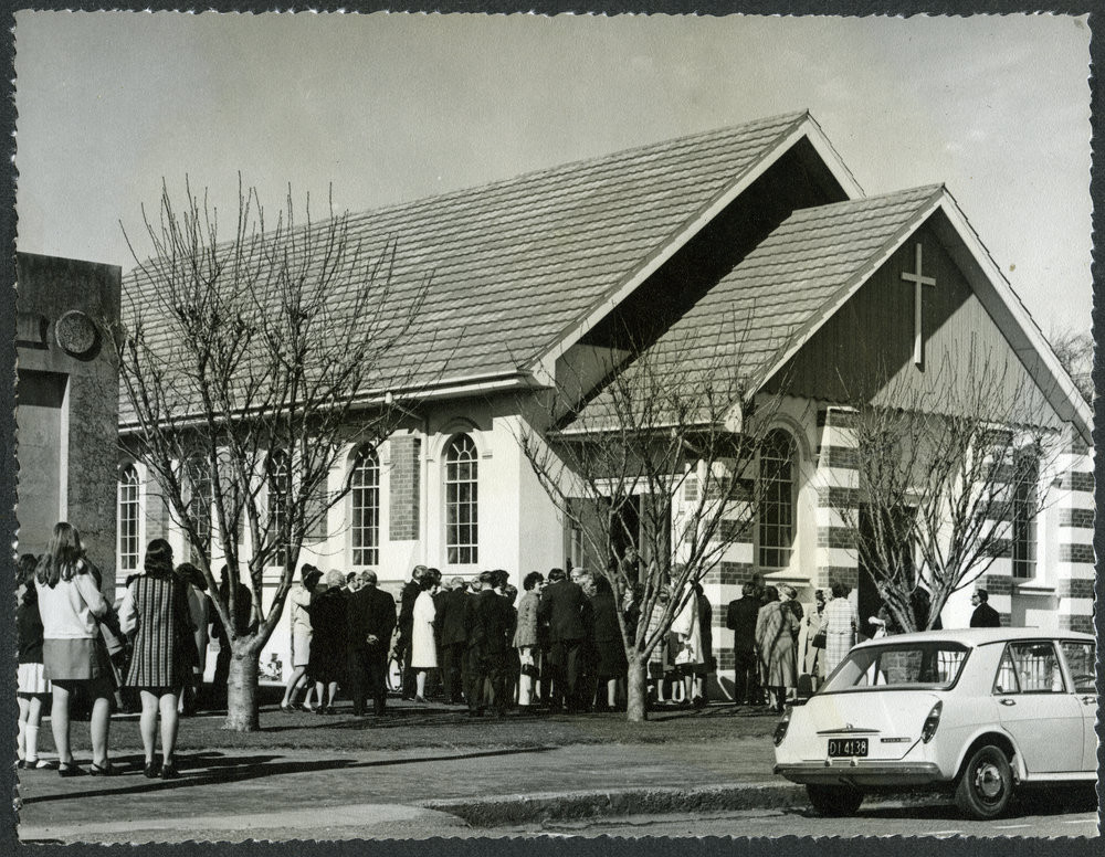Outside photograph of the Rangiora Church with parishioners standing outside. An automobile is parked outside the church. The photograph was taken as part of the centennial celebration of 1972.
A-S39.211.2-2
